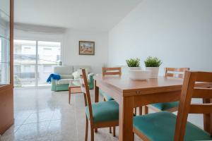 a dining room with a wooden table and chairs at Apartamento SPA Coma-ruga by MarCalma in Comarruga