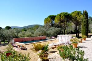 einen Pool in einem Garten mit Pflanzen und Bäumen in der Unterkunft La Bastide de la Provence Verte, chambres d'hôtes in La Roquebrussanne