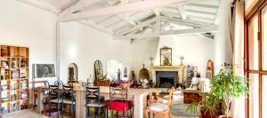 sala de estar con mesa, sillas y chimenea en La Bastide de la Provence Verte, chambres d'hôtes, en La Roquebrussanne