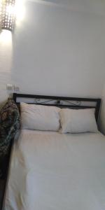 ein weißes Bett mit zwei weißen Kissen darauf in der Unterkunft Fertassa mtls in Moulay Idris