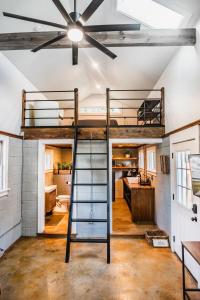 a loft bed in the middle of a room with a kitchen at Olde Village Loft - Unique Park Circle Experience in Charleston