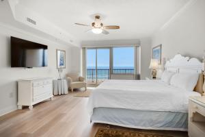 um quarto branco com uma cama e uma grande janela em Hidden Dunes 405 em Panama City Beach