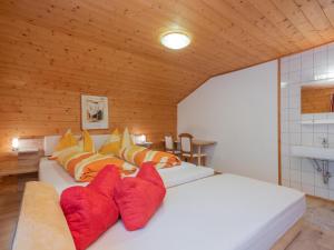een slaapkamer met 2 witte bedden en rode kussens bij Haus Durchegg UG in Wagrain