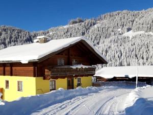 een gebouw bedekt met sneeuw met een berg op de achtergrond bij Haus Durchegg UG in Wagrain