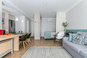 uma sala de estar e cozinha com um sofá e uma mesa em K-Platz 406 - Studio Elegante e Moderno na Melhor Localização do Continente em São José