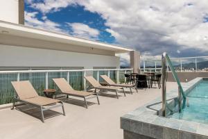 a balcony with chairs and a table and a swimming pool at K-Platz 406 - Studio Elegante e Moderno na Melhor Localização do Continente in São José