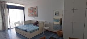 Dormitorio pequeño con cama y espejo en Vista mare a Castro Marina, en Castro di Lecce