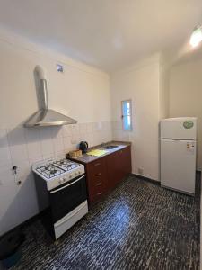uma pequena cozinha com um fogão e um frigorífico em Magnolia Departamento Céntrico em San Fernando del Valle de Catamarca