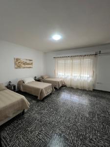 a room with three beds and a carpet at Magnolia Departamento Céntrico in San Fernando del Valle de Catamarca +2 photos
