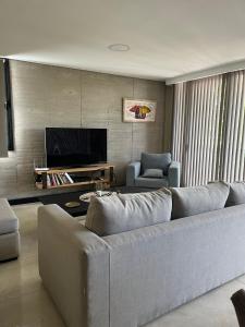 sala de estar con sofá grande y TV en Departamento NUEVO en Capital Mendoza en Mendoza