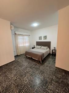 1 dormitorio con cama grande y alfombra en Magnolia Departamento Céntrico en San Fernando del Valle de Catamarca