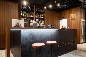 a bar with two stools sitting at a counter at Abrazo Sofia Hotel by HMG in Sofia