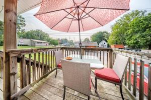 einen Tisch und Stühle auf einer Terrasse mit einem Sonnenschirm in der Unterkunft Cottage in the Falls, 2 b, 2 bath, fireplace in Cuyahoga Falls