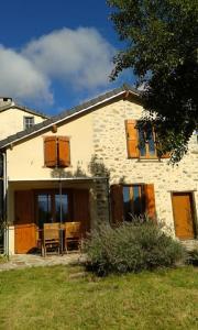 a house with a table and chairs in front of it at Grange en pierres. Grand jardin et belle vue in Saurat