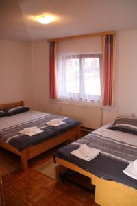 a room with two beds and a window with towels at Apartman Vuvuzela in Kupres