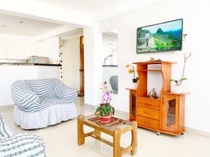 ein Wohnzimmer mit einem Sofa und einem TV an der Wand in der Unterkunft STYLISH & Spacious Apartment in Cusco