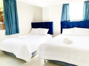 2 Betten in einem Zimmer mit blauen Vorhängen in der Unterkunft STYLISH & Spacious Apartment in Cusco