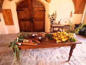 - une table en bois avec des fruits et des légumes dans l'établissement Villa Pozzolo Exclusive All-inclusive, amazing music, food, wine, party, heated swimming pool and more, à Montaione