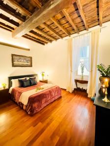 1 dormitorio con 1 cama grande y suelo de madera en Trevi Fountain Luxury Guest House, en Roma