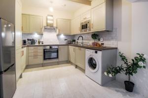 a kitchen with a washing machine and a sink at Luxurious 2 Bedroom Apartment in City Centre in Nottingham