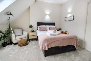 a bedroom with a large bed and a chair at Luxurious 2 Bedroom Apartment in City Centre in Nottingham