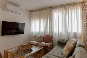 uma sala de estar com um sofá e uma mesa em Piso Picasso em Granada