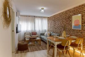 uma sala de estar com uma mesa e uma parede de tijolos em Piso Picasso em Granada