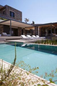 a swimming pool with lounge chairs and a building at Ohlive II sea view Kechria in Skiathos Town