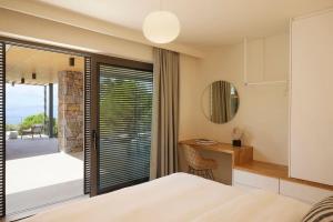 a bedroom with a bed and a desk and a window at Ohlive II sea view Kechria in Skiathos Town