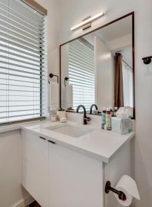 a white bathroom with a sink and a mirror at The Marymaker by Lodgewell - It's Super Suite Y'all in Austin