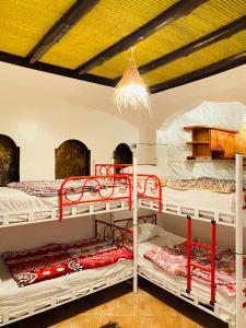 a room with two bunk beds and a ceiling at Azoul Surf Hostel Taghazout in Taghazout