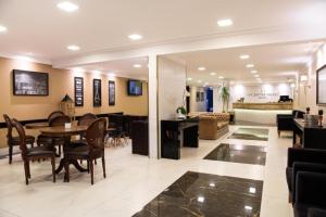 a dining room and living room with a table and chairs at HOTEL PIACENTINI in Campo Mourão