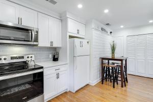 a kitchen with white cabinets and a table in it at Pender Lane 13 in Hilton Head Island