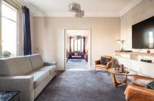 un soggiorno con divano e tavolo di Spacieux et élégant appartement Porte des ternes a Parigi