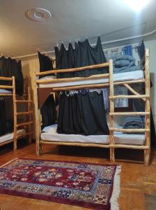 2 Etagenbetten in einem Zimmer mit einem Teppich in der Unterkunft The Hideout - Hiraeth in Manali