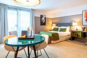 una camera d'albergo con letto e tavolo di Fraser Suites Paris La Défense a Courbevoie