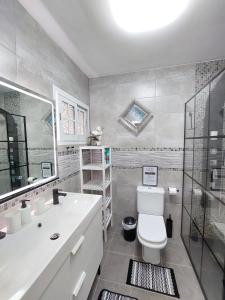 a bathroom with a toilet and a sink and a shower at Brisa Marina - Vista Golf 2 - WiFi - swimming pool in Caleta De Fuste