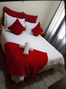 un letto rosso e bianco con cuscini rossi di LightStone Guesthouse a Centurion