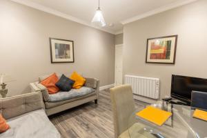 a living room with a couch and a television at Two Bedroom Apartment Within Walking Distance to City Centre in Edinburgh