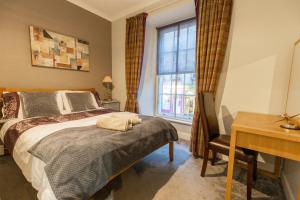 a bedroom with a bed and a desk and a window at Two Bedroom Apartment Within Walking Distance to City Centre in Edinburgh