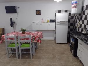 una pequeña cocina con mesa y nevera en Brisas del Mar ll en San Clemente del Tuyú