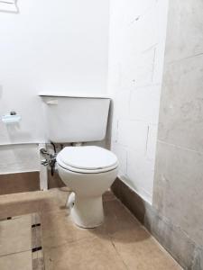 a bathroom with a white toilet in a room at Jazmines Apart in Martínez