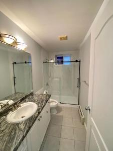 a white bathroom with a sink and a shower at Anne's BNB in Surrey