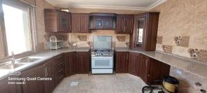 a kitchen with wooden cabinets and a stove top oven at noor apartment in Wadi Musa