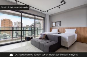 um quarto de hotel com uma cama e um sofá em Charlie Itaim em São Paulo