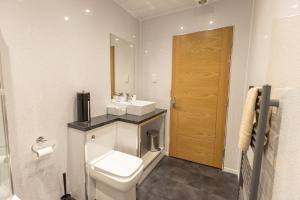 y baño con aseo, lavabo y espejo. en New 2 bed apartment with stunning views of Arthur Seat Mountain en Edimburgo