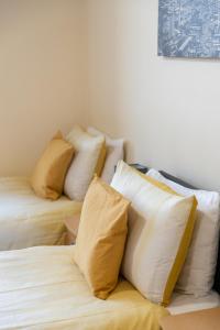 um grupo de almofadas em cima de uma cama em New 2 bed apartment with stunning views of Arthur Seat Mountain em Edimburgo