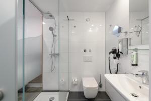 y baño con ducha, aseo y lavamanos. en CiTTy Hotel Schweinfurt, en Schweinfurt