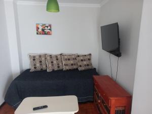 1 dormitorio con 1 cama y TV en la pared en Hermoso dpto centrico externo c/ balcones en Córdoba