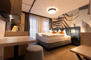um quarto com uma cama, uma secretária e uma mesa em CARPE SOLEM Jules em Obertauern